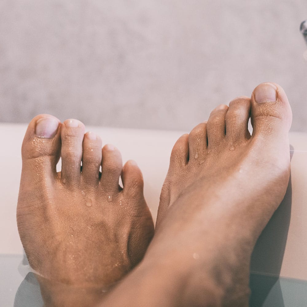 view of feet soaking in hot water